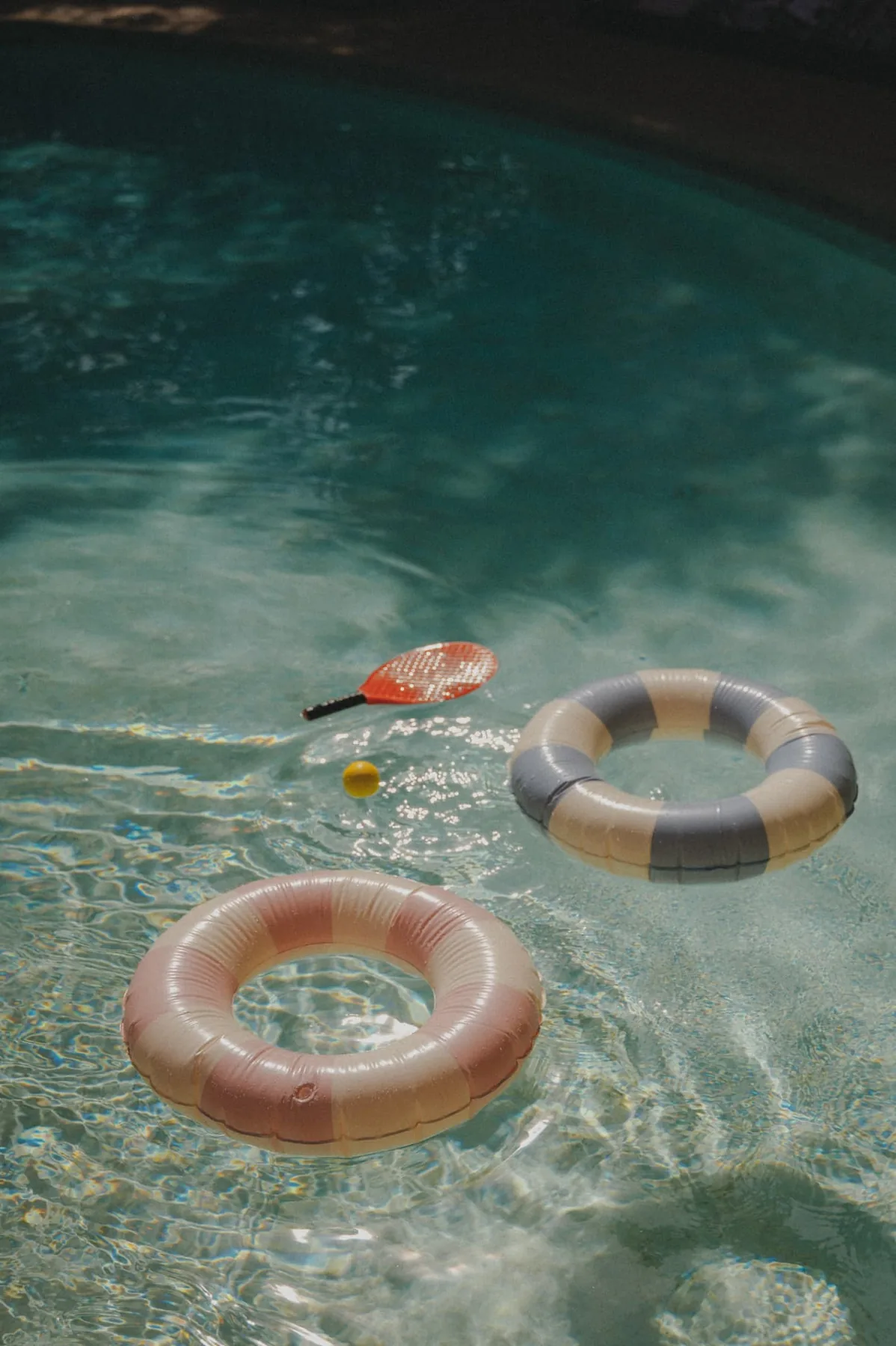 Deux bouées et une raquette dans la piscine