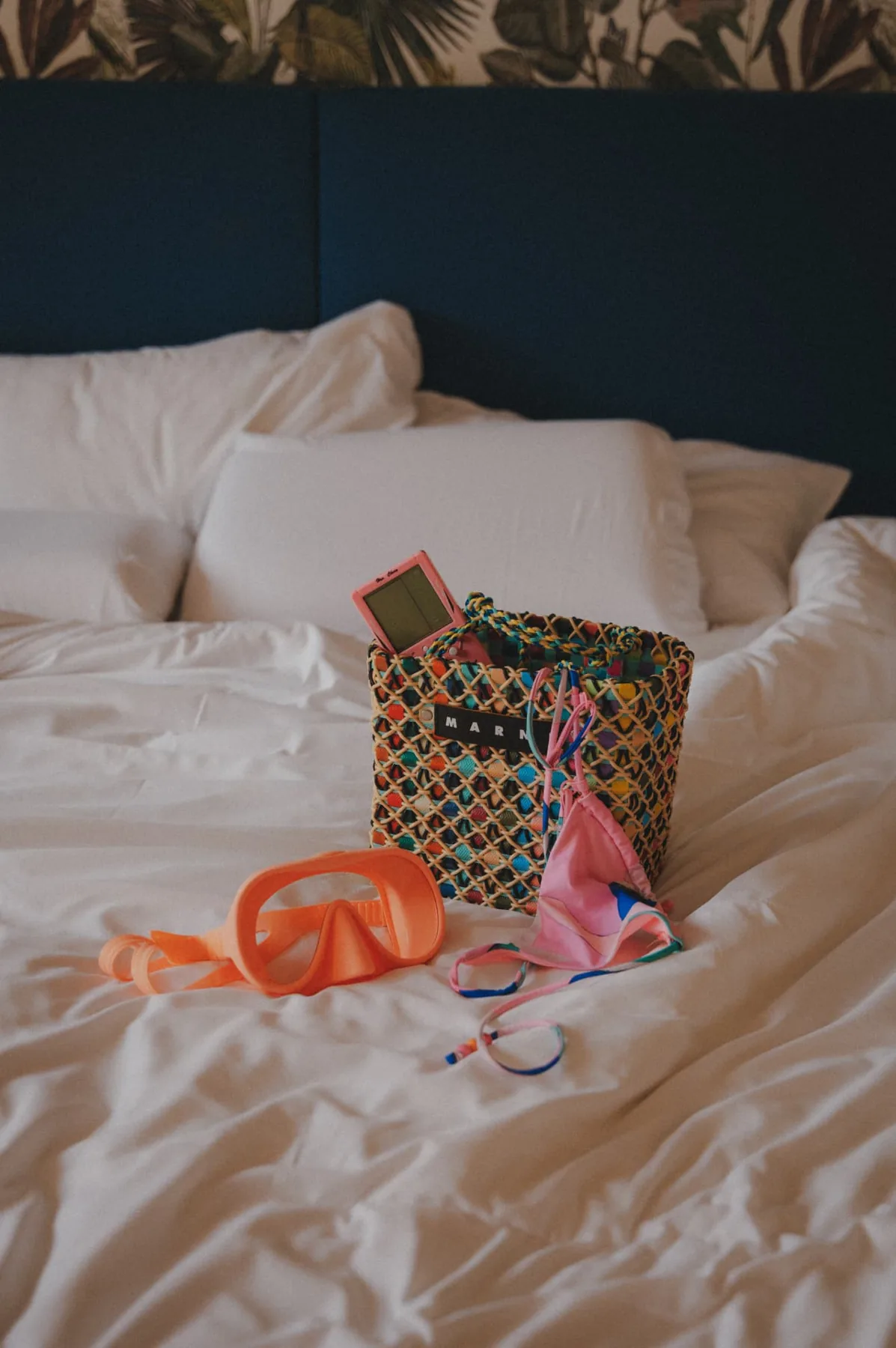 Beach basket, mask and swimsuit on the bed