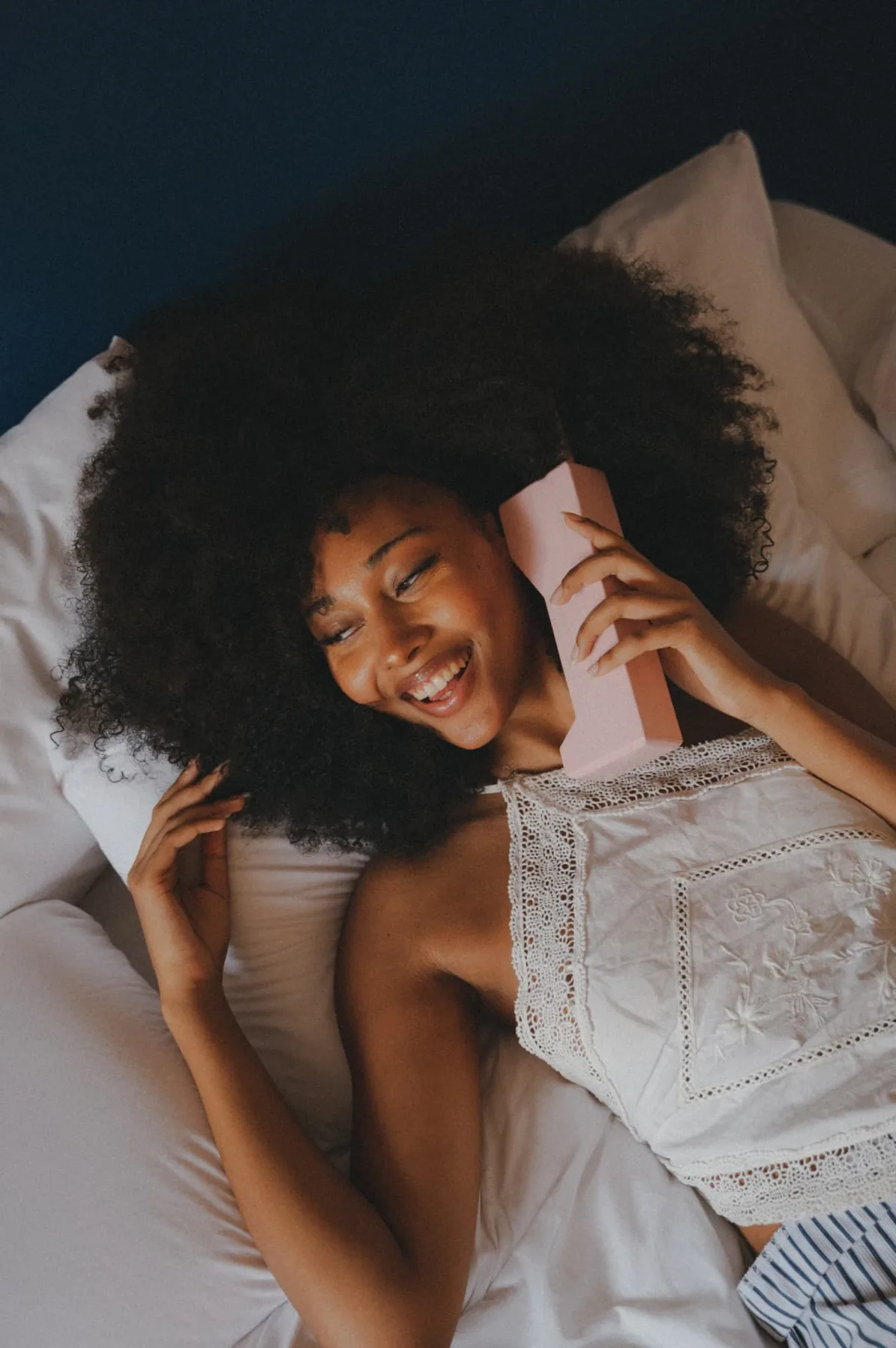 A guest on the phone, lying on a Motel bed