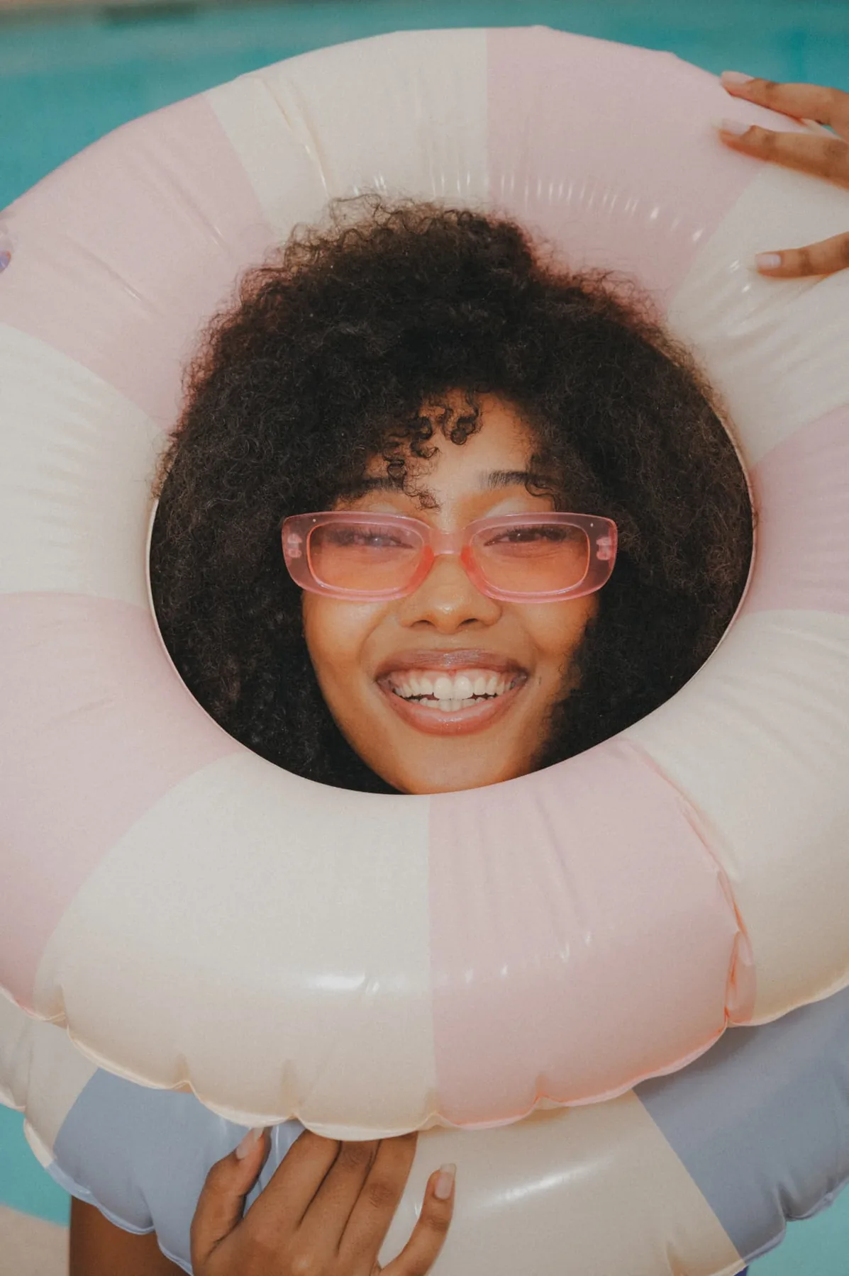 Smiling through a pink pool ring