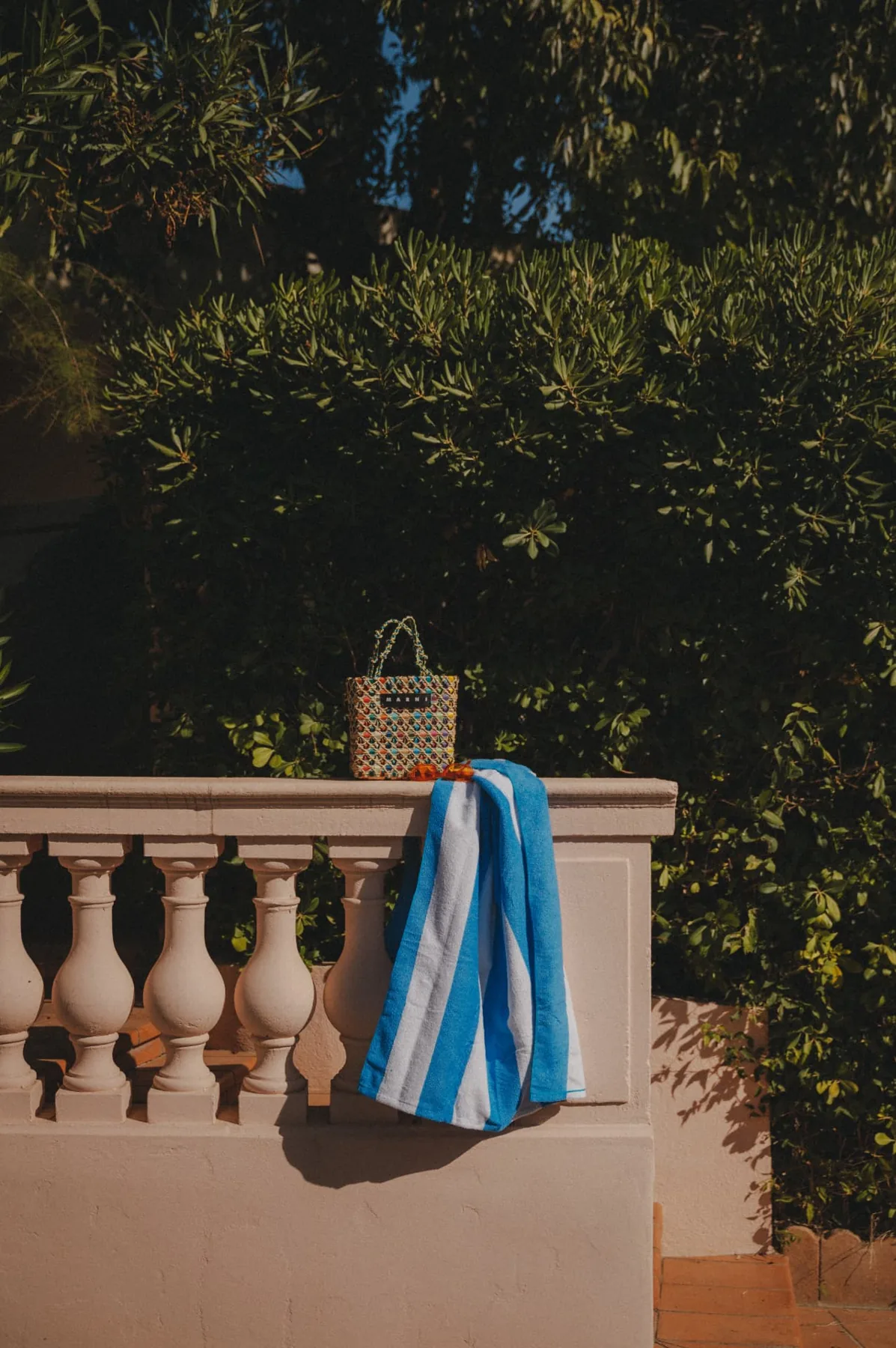 Striped towel and basket on the balustrade