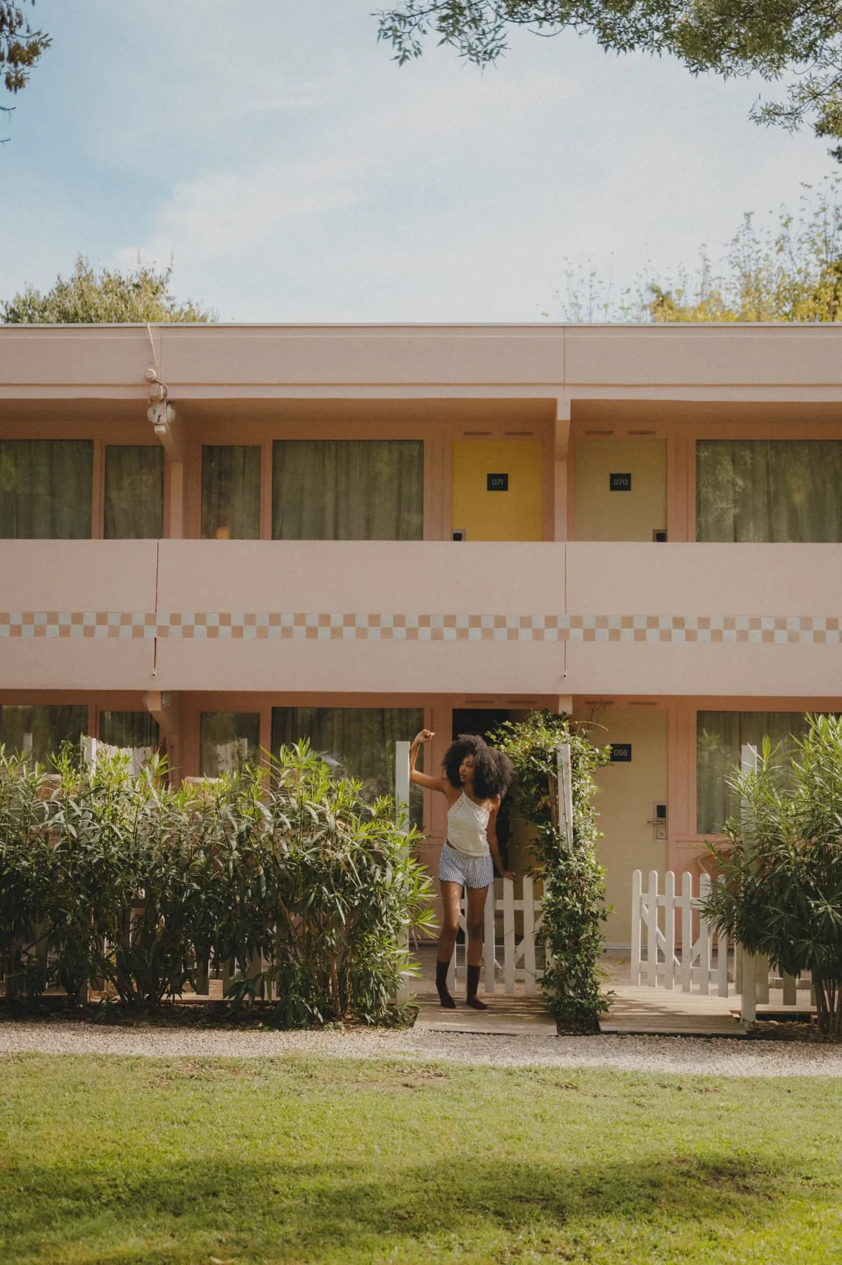 Pink motel building among pines and palms